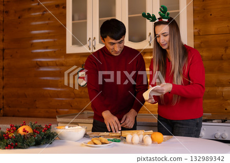 A couple is preparing Christmas treats in the kitchen A couple is preparing Christmas treats in the kitchen 132989342