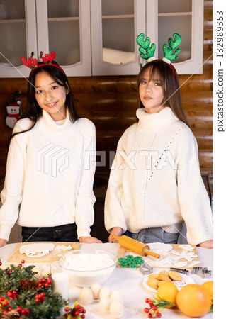 The two women are preparing festive Christmas cookies in a cozy kitchen The two women are preparing festive Christmas cookies in a cozy kitchen 132989353