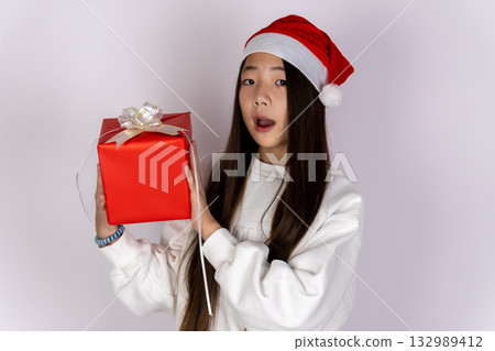 Little girl is holding a Christmas gift, ready to give it to someone Little girl is holding a Christmas gift, ready to give it to someone 132989412