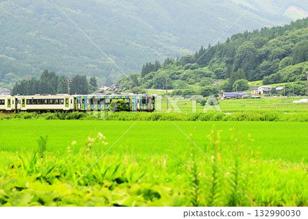 Tono in summer: Kamaishi Line and trains seen from the rice paddy area Tono in summer: Kamaishi Line and trains seen from the rice paddy area 132990030