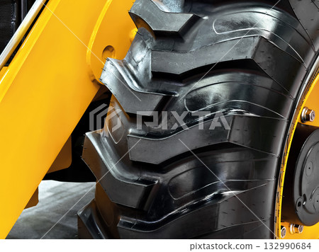 Heavy-duty tractor tire showcasing rugged tread design for enhanced traction and stability on uneven terrain Heavy-duty tractor tire showcasing rugged tread design for enhanced traction and stability on uneven terrain 132990684