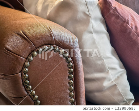 Elegant leather sofa corner with decorative pillows in a cozy living room setting 132990685
