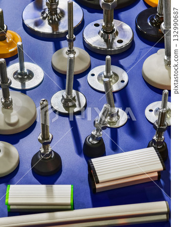 Various mechanical components displayed on a vibrant blue surface, showcasing multiple fasteners and mounts in different shapes Various mechanical components displayed on a vibrant blue surface, showcasing multiple fasteners and mounts in different shapes 132990687