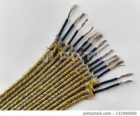 Crafted yellow and black twisted cords arranged neatly on a white surface for various uses in DIY projects or repairs 132990688