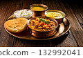 Pakistan food, Traditional Pakistani breakfast with halwa, puri, and chana, served on a rustic 132992041