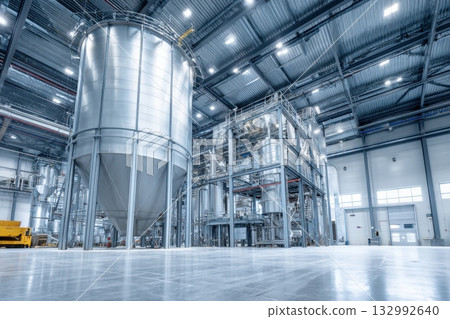 Industrial farm agricultural silos for storage and drying of grains, wheat, corn, soy, sunflower with sunlight. Large metal grain tanks and processing equipment in modern facility. Agriculture, food. 132992640