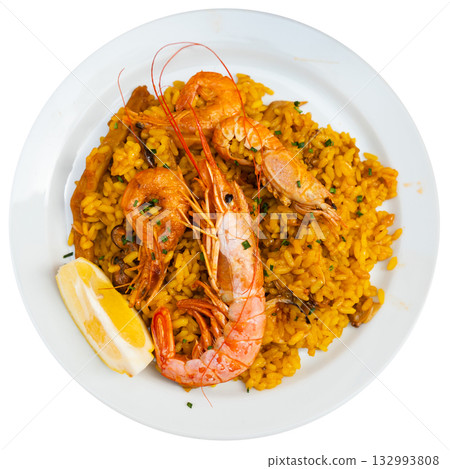 Paella made of rice and different seafood served in plate with table appointments Paella made of rice and different seafood served in plate with table appointments 132993808