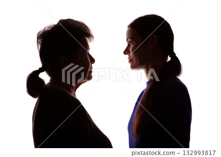 Silhouette elderly woman opposite young woman, mother and daughter - isolate 132993817