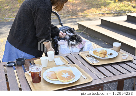 一位女士和她的吉娃娃犬在咖啡館的露臺上放鬆休息 132994228