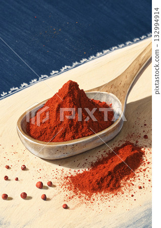red paprika powder in a wooden spoon red paprika powder in a wooden spoon 132994914