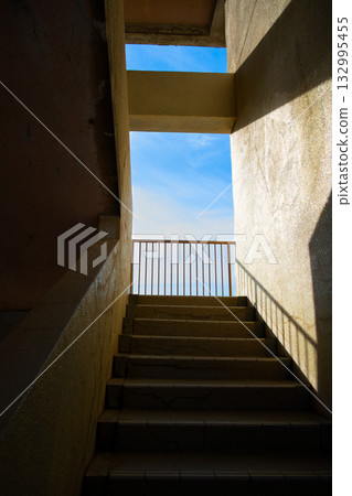 A beautiful contrast of light and shadow on the stairs and blue sky A beautiful contrast of light and shadow on the stairs and blue sky 132995455