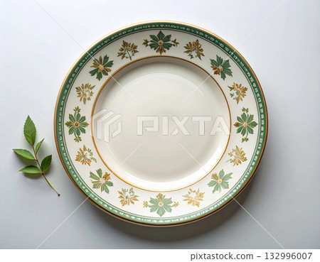 Timeless design. Ceramic plate with a green and gold pattern on a white background. Porcelain kitchenware. Close-up. Top view. Timeless design. Ceramic plate with a green and gold pattern on a white background. Porcelain kitchenware. Close-up. Top view. 132996007