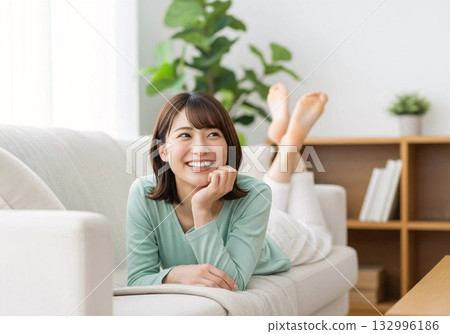 Smiling woman relaxing on the sofa Stylish background 132996186