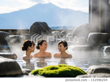 A woman bathing in a hot spring with a spectacular view in the background 132996204