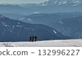 Mountaineers standing on snowy mountain ridge enjoying scenic view 132996227