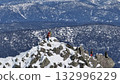 Mountaineers reaching snowy mountain peak 132996229