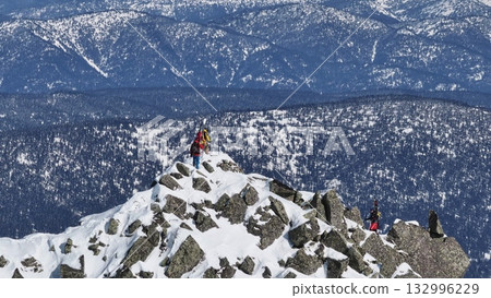 Mountaineers reaching snowy mountain peak Mountaineers reaching snowy mountain peak 132996229