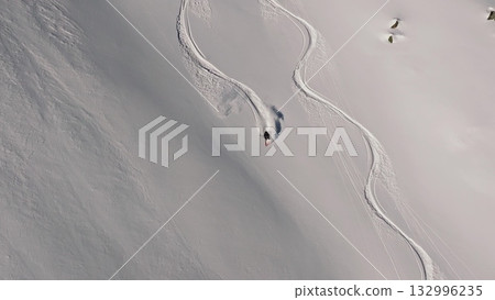 Professional skier making turns on a snowy slope Professional skier making turns on a snowy slope 132996235