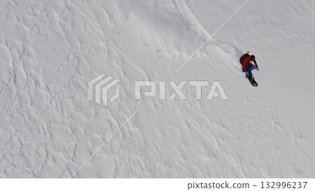 Snowboarder riding fresh powder snow on mountainside Snowboarder riding fresh powder snow on mountainside 132996237
