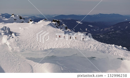 Mountaineers walking on snowy mountain ridge 132996238