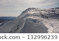 Climbers traversing snowy mountain ridge in stunning winter scenery 132996239