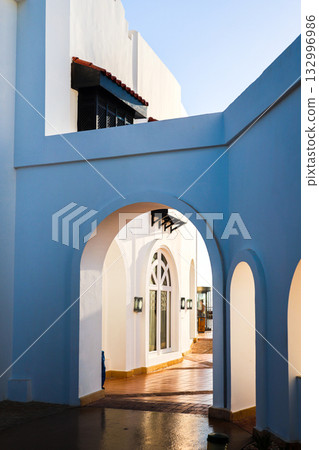 A beautiful arched passage to the white entrance of the building 132996986