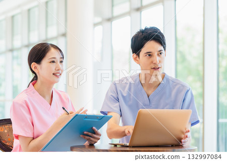 Male and female medical workers working in a hospital Male and female medical workers working in a hospital 132997084