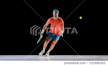 Focused tennis player tracking ball with strong eye contact and balance 132998165