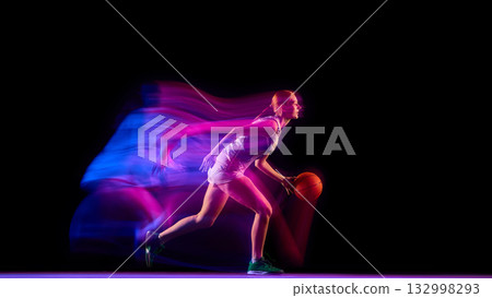 Female basketball player running with ball in neon motion blur. Female basketball player running with ball in neon motion blur. 132998293
