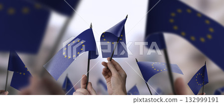 European Union flags in their hands on a blurred urban background 132999191