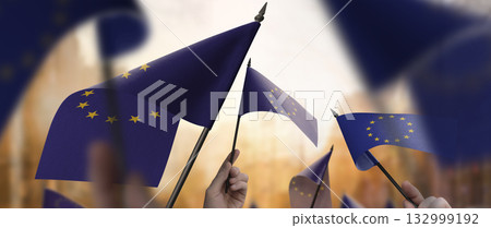 European Union flags in their hands on a blurred urban background 132999192