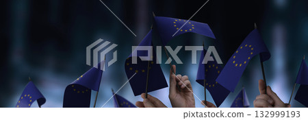 European Union flags in their hands on a blurred urban background 132999193