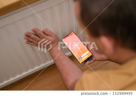Smartphone connecting to heating radiator. Remote home control system on a smartphone. 132999495