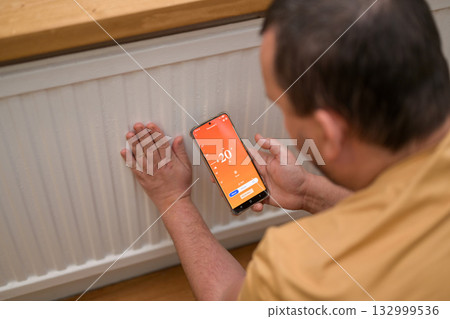Smartphone connecting to heating radiator. Remote home control system on a smartphone. 132999536