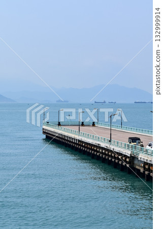 The pier at Tsim Sha Tsui, Hong Kong in the sunny day. Travel and nature scene. Seascape in Hong Kong. Sea background. 132999914