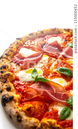 Delicious artisanal pizza topped with tomato sauce, fresh mozzarella, prosciutto, basil leaves, and a drizzle of olive oil Delicious artisanal pizza topped with tomato sauce, fresh mozzarella, prosciutto, basil leaves, and a drizzle of olive oil 133000452