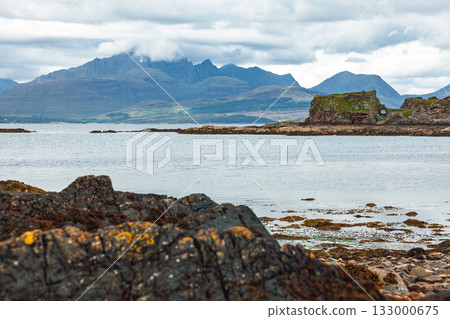 Historic Dunscaith Castle overlooking sea and Cuillin hills Scotland Historic Dunscaith Castle overlooking sea and Cuillin hills Scotland 133000675