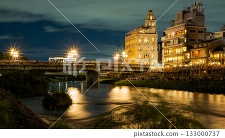 The glittering streets of Kyoto, Japan. Night view of the Kamo River, Kyoto, around Shijo Ohashi Bridge The glittering streets of Kyoto, Japan. Night view of the Kamo River, Kyoto, around Shijo Ohashi Bridge 133000737