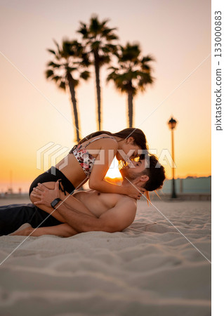 Romantic Sunset Moment Between Couple on the Beach With Palm Trees in the Background Romantic Sunset Moment Between Couple on the Beach With Palm Trees in the Background 133000883