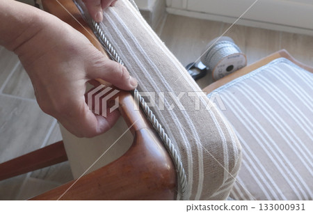 Anonymous person glues decorative braid. Antique furniture restoration. Crafts and hobbies. 133000931