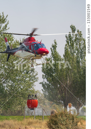 Firefighting Helicopter Collecting Water in Action 133001549