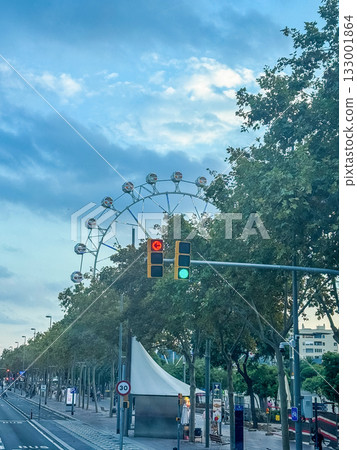 Ferris Wheel Behind Green Trees and City Traffic Lights at Dusk Ferris Wheel Behind Green Trees and City Traffic Lights at Dusk 133001864