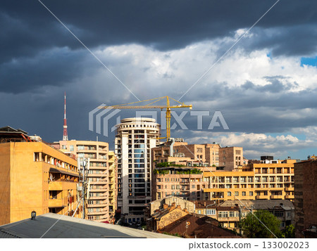 rainy clouds over sunlit buildings in Yerevan city 133002023