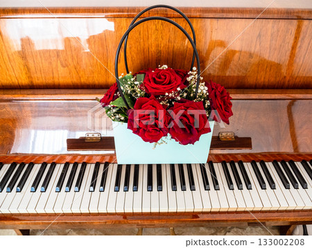 bunch of fresh red roses in bag box on piano bunch of fresh red roses in bag box on piano 133002208