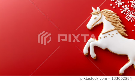 White unicorn-shaped cookie with golden details on a vibrant red background for festive celebrations 133002894