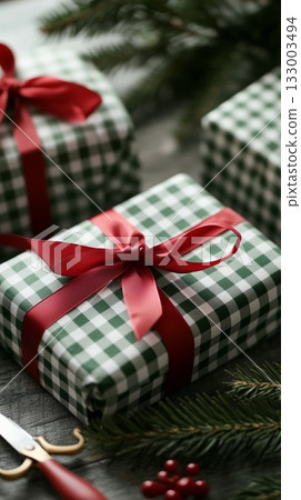 Beautifully Wrapped Gifts With Red Ribbons and Greenery on Wooden Table During Holiday Season Beautifully Wrapped Gifts With Red Ribbons and Greenery on Wooden Table During Holiday Season 133003494