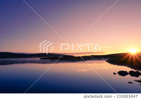 Golden Mist Over Tranquil Lake at Sunrise 133003847