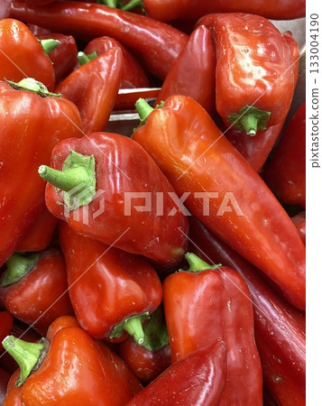 Fresh red bell peppers in a close-up view, showcasing their vibrant color and texture 133004190