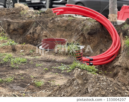 Construction site with red cables and cables in ground, showcasing infrastructure development 133004207