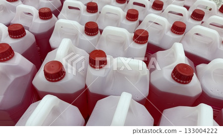 Red and white plastic jugs arranged in rows, viewed from above, creating a pattern background Red and white plastic jugs arranged in rows, viewed from above, creating a pattern background 133004222